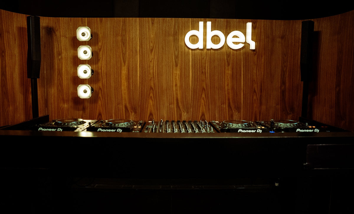 Studio 01 de dbel: cabina de DJ de frente con el logo iluminado
