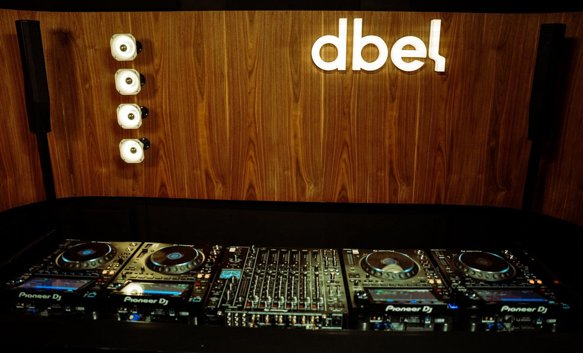 Cabina de DJ del Studio 01 de dbel con los CDJ y el logo