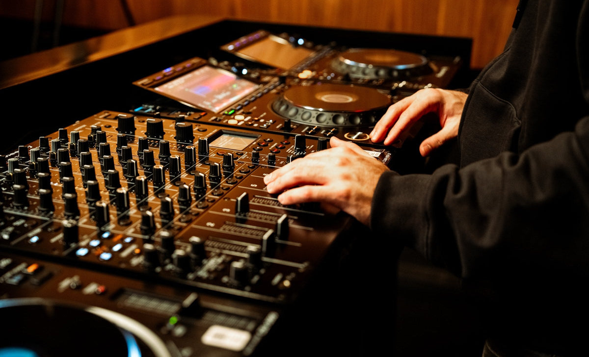 Manos sobre el mixer y los CDJ en una clase individual de DJ en dbel